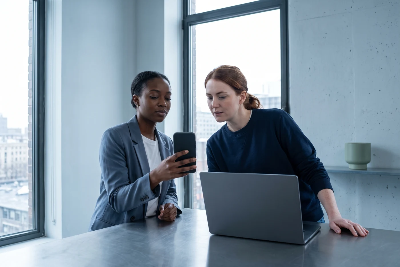 A product owner and an engineer reading a customer note together on a phone